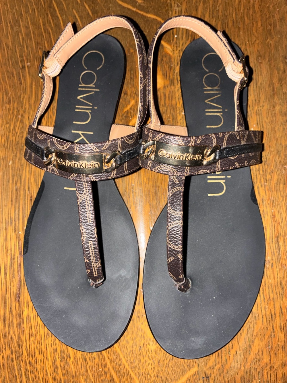Calvin Klein Black Footbed Brown Monogram T-Strap Sandals with Gold Plaque